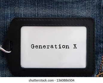 A Black White Card With Text GENERATION X  In Black ID Card Holder On Denim Jeans Background.