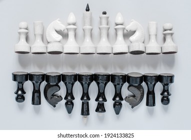 Black and white chess pieces are stacked in a row, top view
