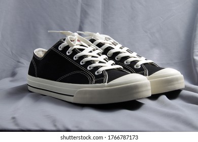 Black and white classic style canvas sneaker, shoot on a grey fabric as background - Shutterstock ID 1766787173