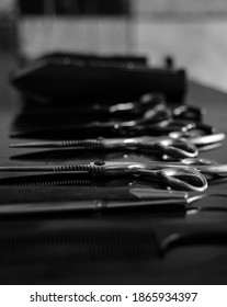 Black And White Close Up Of Hair Barber Equipment In The A Queues On The Table. Barber Shop Tools