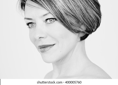 Black And White Close Up Portrait Of Beautiful Middle Aged Woman With Short Hair Looking Aside Over White Background - Beauty, Skin Care Or Anti Aging Concept