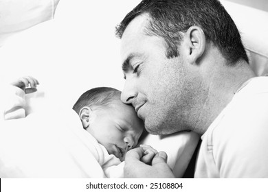 Black And White Close-up Of Father Holding His Newborn Baby