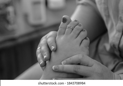 Black And White Close-up Of Foot Massage And Toe Ring.