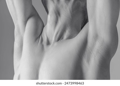 Black and white close-up of a muscular male back with arms raised, highlighting muscle definition and skin texture in a minimalist style. Concept of body aesthetics, nature and beauty of human. - Powered by Shutterstock