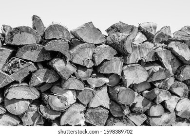 A black and white, closeup photo of a high stack of freshly cut firewood.  - Shutterstock ID 1598389702