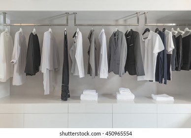 Black And White Color Tone Clothes Hanging On Rail In White Closet