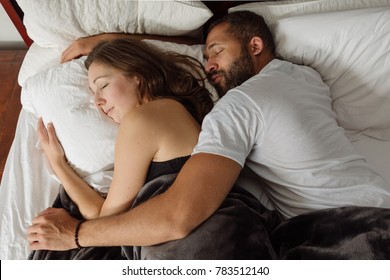 Black And White Couple Cuddling And Sleeping In Bed