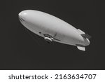 Black and white detail of an unmarked or blank blimp. A white airship against a clear sky. Use for advertising, customizable and room for copy and or text. 