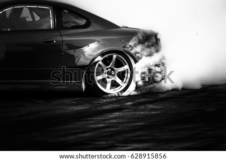 Black and white drifting car, Car wheel drifting and smoking on track.