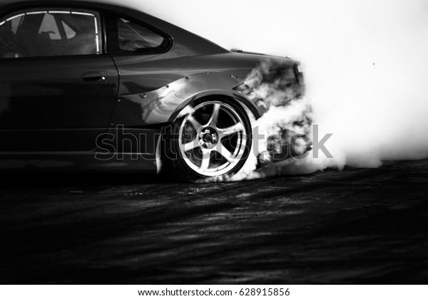 Black and white drifting car, Car wheel drifting\
and smoking on track.