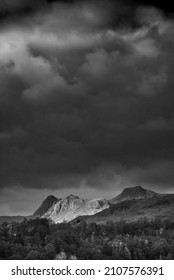 Black and white Epic landscape image of stunning Autumn sunset light across Langdale Pikes looking from Holme Fell in Lake District