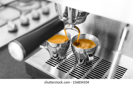 Black & white of espresso being made on home espresso machine. Only the espresso in color.