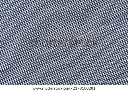 Black and white fabric with houndstooth pattern and seam.