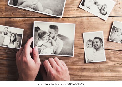 Black and white family photos laid on wooden floor background. - Shutterstock ID 291653849