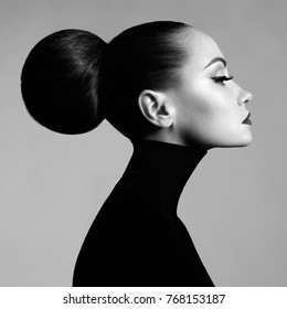 Black and white fashion art studio portrait of beautiful elegant woman in black turtleneck.  Hair is collected in high beam.  Elegant ballet style