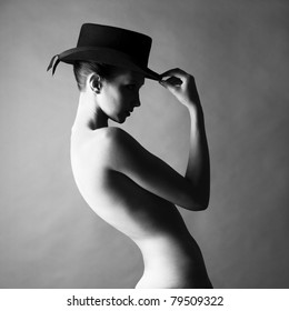 Black and white fashion portrait of naked lady with hat