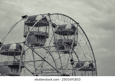 black and white ferris wheel in dramatic cloudy conditions - Powered by Shutterstock