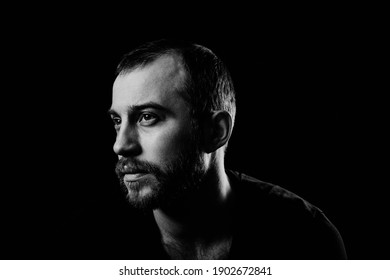 Black And White Half Profile Portrait Of Young Caucasian Man With Beard And Moustache Wearing Black T-shirt