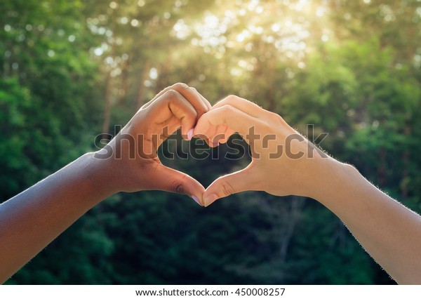 Black and white hands in heart shape,\
interracial friendship