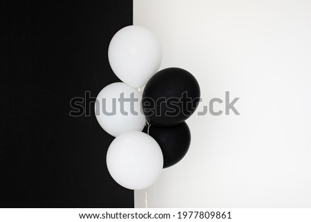 Black and white helium balloons on black and white background with copyspace
