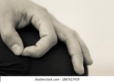 Black and white horizontal closeup of hand gesture or mudra, which directs energy and maintains focus during meditation by bringing tip of thumb and index fingers together, forming a circle