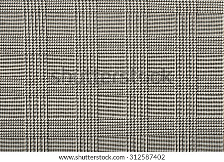 Black and white houndstooth pattern in squares. Black and white wool twill pattern. Woven dogstooth check design as background.