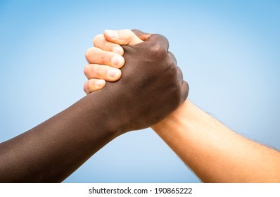 Black And White Human Hands In A Modern Handshake To Show Each Other Friendship And Respect - Arm Wrestling Against Racism