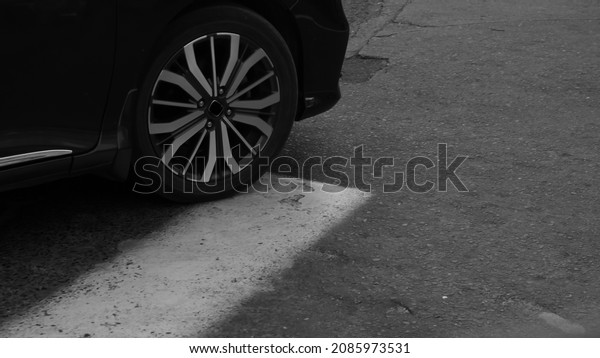 Black and white image of car stopped on the\
zebra crossing.