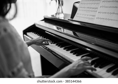 Black and white image of female playing the piano - Powered by Shutterstock