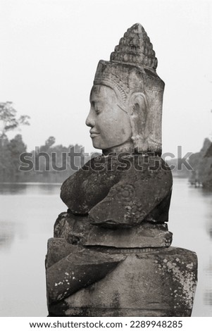 Black and white image of figure from Churning of the Ocean of Milk balustrade, South Gate bridge to Angkor Thom, near Angkor Wat, Cambodia