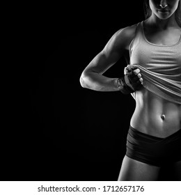 Black And White Image Of Fit Female Model With Perfect Torso In Studio. Sensual Young Female Posing In Black Background With Copy Space.