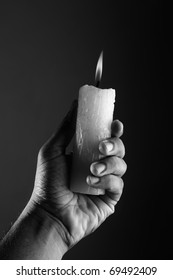 Black And White Image Of A Hand Holding A Lighted Candle