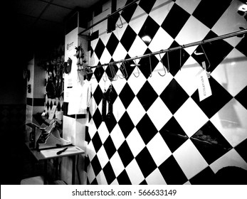 Black And White Image Of The Interior Of An Empty Butcher Shop During The Night. Reflections Of The Window Glass And Checked Pattern On The Inside Wall