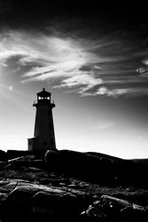 A Black And White Image Of The Lighthouse At Peggy's Cove, Nova Scotia, Canada. Image Shows Rock And Cloudy Sky