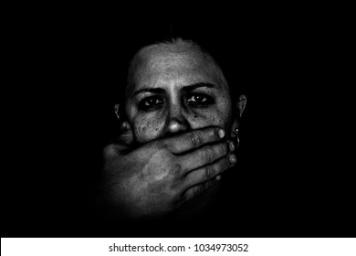 Black And White Image Of Man's Hand Covering Woman's Mouth On Black Background. Domestic Violence. Fear. No Voice. Removal Of Free Speech