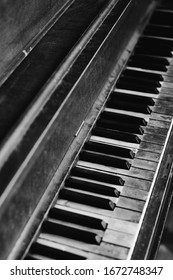 Black And White Image Of An Old Worn Out Piano. Old Key Board. Ancient Piano Background. 