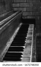 Black And White Image Of An Old Worn Out Piano. Old Key Board. Ancient Piano Background. 