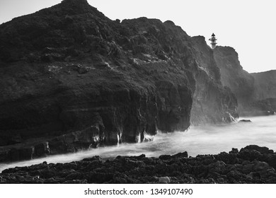 Black and white image of a seascape with mountains and rocks, long exposure and waves that become foam. Image for black and white backgrounds. Tenerife island wallpaper