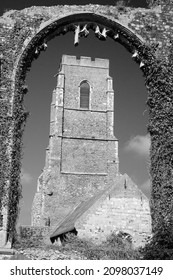 Black and white image of St Andrew's Church at Covehithe,  Suffolk, England, viewed through the arch of its predecessor, now in ruins. - Shutterstock ID 2098037149