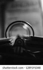 Black And White Image Of A Three Ring Binder Illuminated By A Desk Light During The Late Night Hours Vertical Setup Closeup Of Rings From The Lower Part Of The Image
