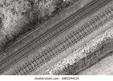 Black and white image of two railway tracks which consists of two parallel steel rails, anchored perpendicular to members called ties (sleepers) of concrete to maintain a consistent distance apart.