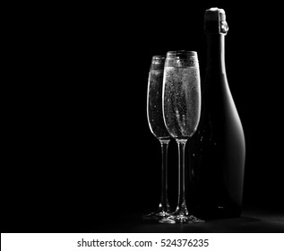 Black And White Image Of Two Wine Glasses With Champagne And A Bottle Of Champagne, The Outlines And Highlights, Black Background