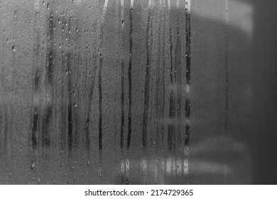 Black and white image of water on a clear glass wall.