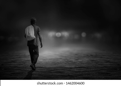 The black and white image of a young man wandering on the road in the night alone