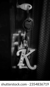 Black and white K keychain in the dark hanging from door - Shutterstock ID 2354836719