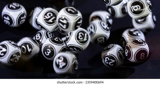 Black and white lottery balls in a bingo machine. Lottery balls in a sphere in motion. Gambling machine and euqipment. Blurred lottery balls in a lotto machine.