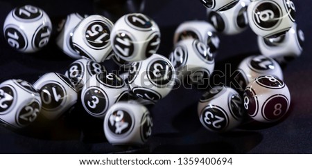 Black and white lottery balls in a bingo machine. Lottery balls in a sphere in motion. Gambling machine and euqipment. Blurred lottery balls in a lotto machine.