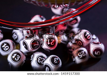 Black and white lottery balls in a bingo machine. Lottery balls in a sphere in motion. Gambling machine and euqipment. Number 21.