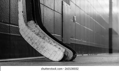 Black And White Macro Shot Of Hockey Stick Blades Laid On A Dirty Arena Floor - Shallow Depth Of Field