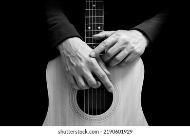 black and white male guitarist hands on acoustic guitar body, isolated on black. music background - Shutterstock ID 2190601929